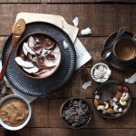 bowl di yogurt greco con cioccolato, cocco e burro di arachidi