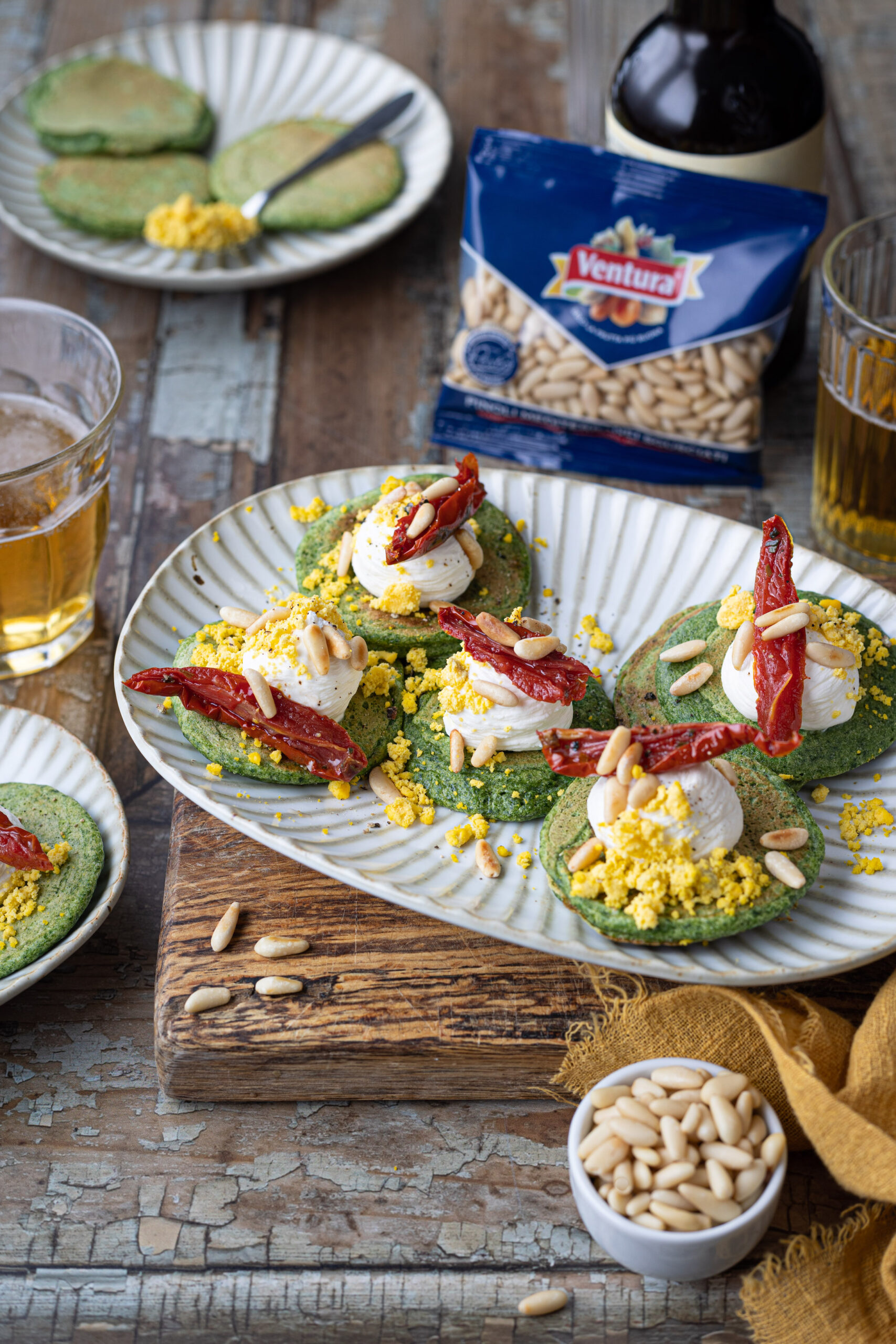 Blinis con mimosa d'uovo, pomodori secchi e pinoli